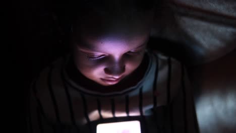 child using smartphone at night