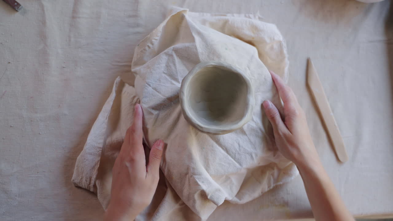 manos dando forma a un cuenco de arcilla
