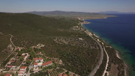 Orilla-Del-Mar-Con-Cabañas-Y-Colinas-Verdes-Vista-Aérea-De-La-Playa-De-Trikorfo-Grecia