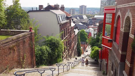 people ascending the staircase montagne de bueren in liège, belgium. the famous stairway has 374 steps and was built in 1881