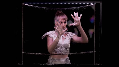 slow motion: girl does tricks with soap bubbles. she plays by her hands on soap wall, with iridescent reflected light