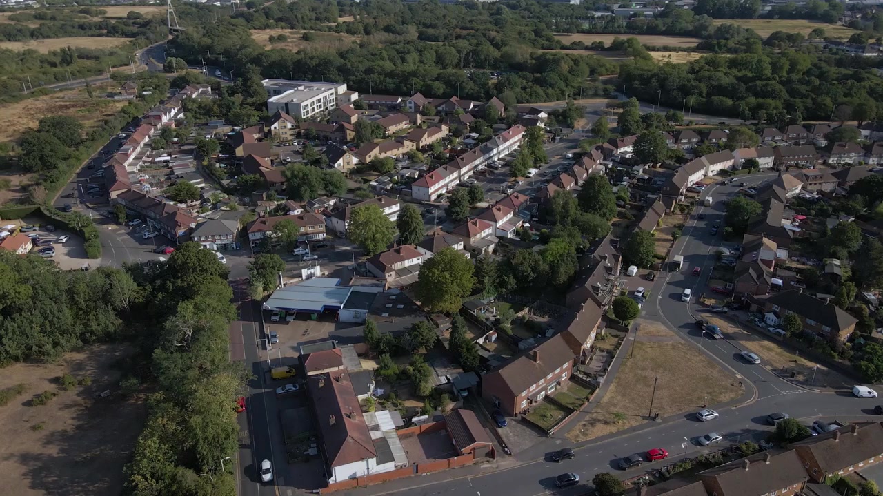 Riprese aeree con drone del centro di Uxbridge con aree commerciali visibili e traffico stradale. Questo mostra un vivace centro suburbano, evidenziando infrastrutture, sviluppo e attività quotidiane a Londra