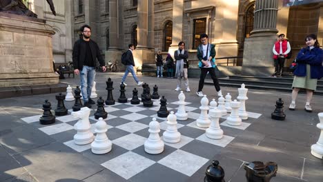 people playing giant chess in public square