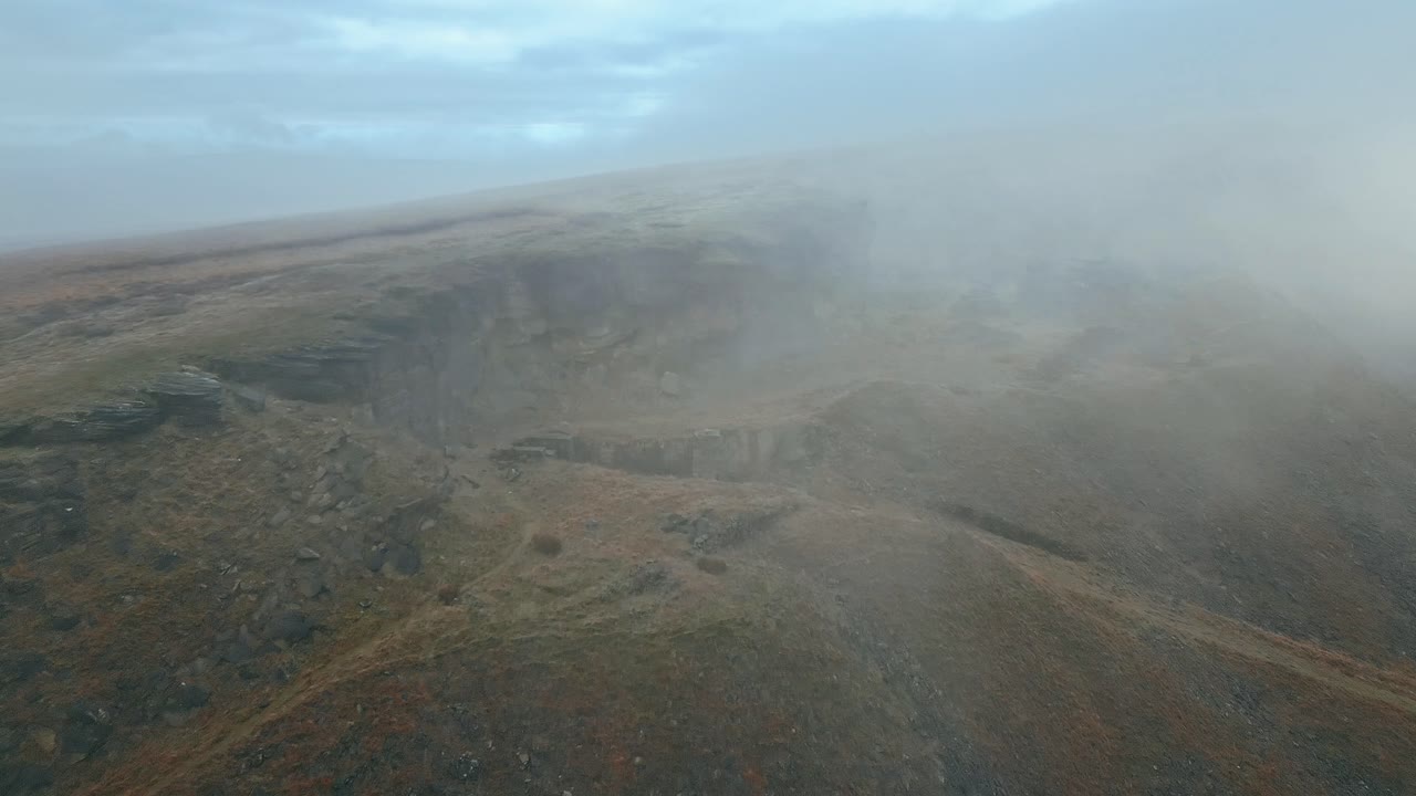 vista aérea por drones de las nubes moviéndose lentamente sobre las colinas peninas, en una mañana nublada, con colinas doradas y hermosos afloramientos rocosos y páramos