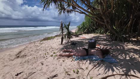 young curvy woman relaxing on the beach palm tree shade, tropical holiday destination