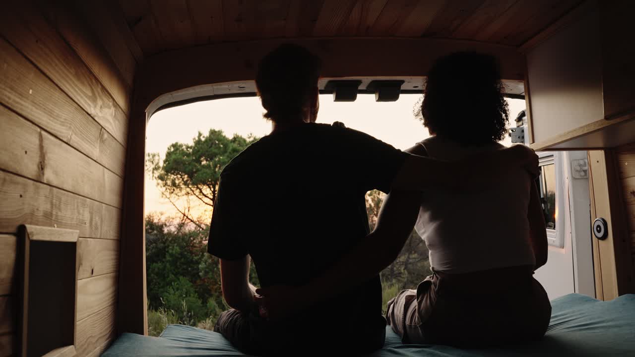 Couple enjoying sunset view from campervan