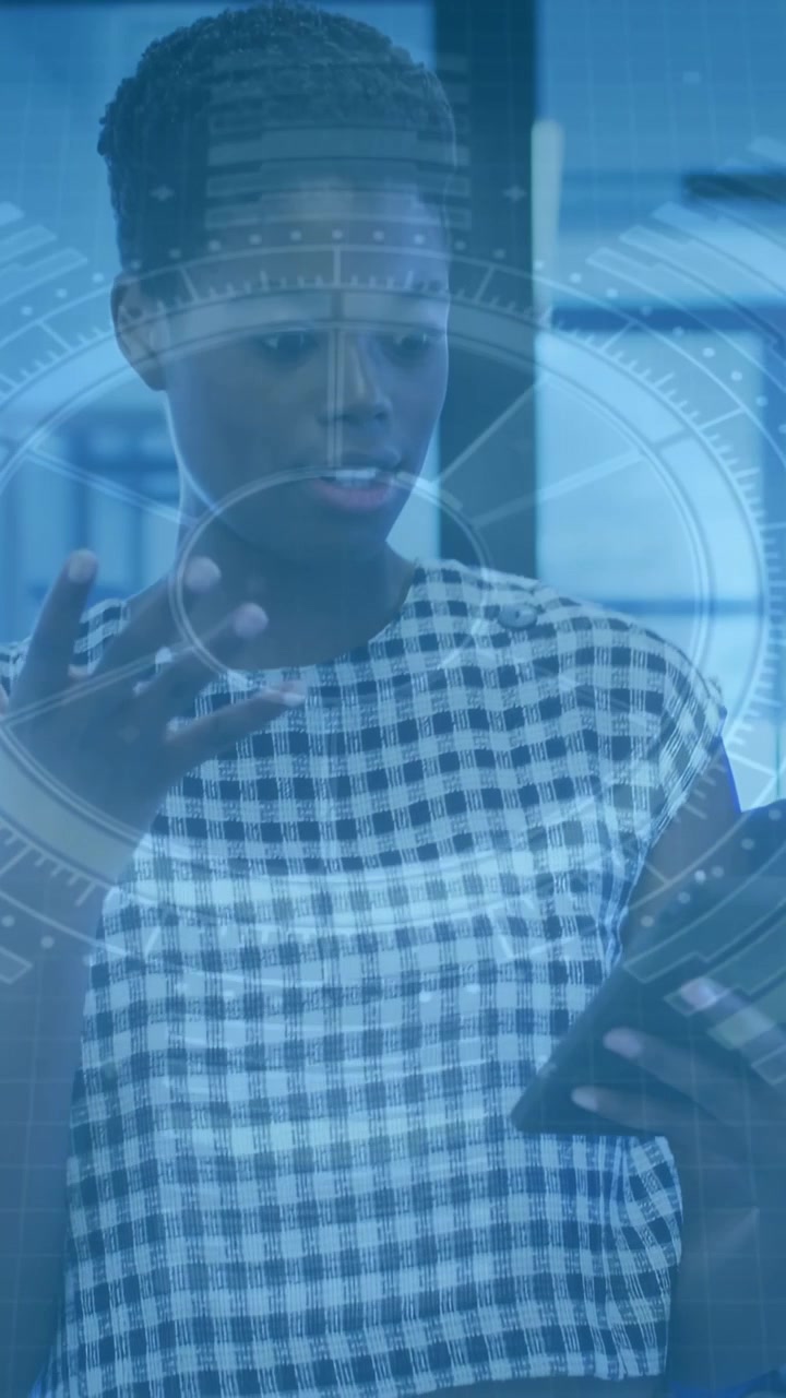 Vertical video: Woman reading tablet activating HUD in tech hub, showing charts and explaining data