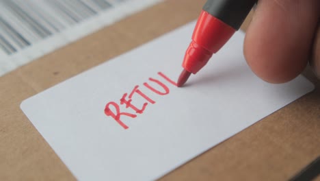 a red marker is used to write 'return' on a white shipping label