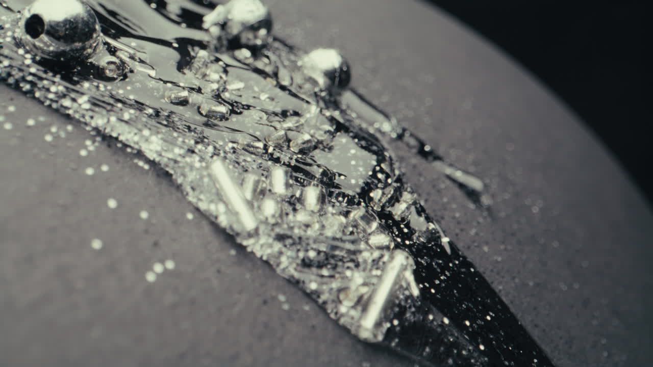 Abstract Silver Beads and Liquid on Dark Surface