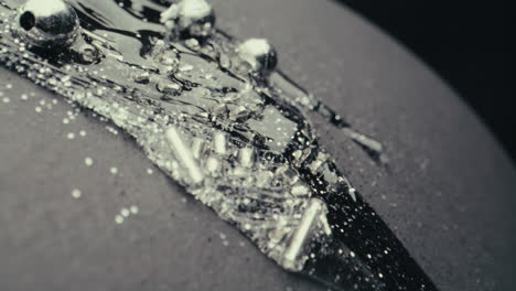 abstract silver beads and liquid on dark surface
