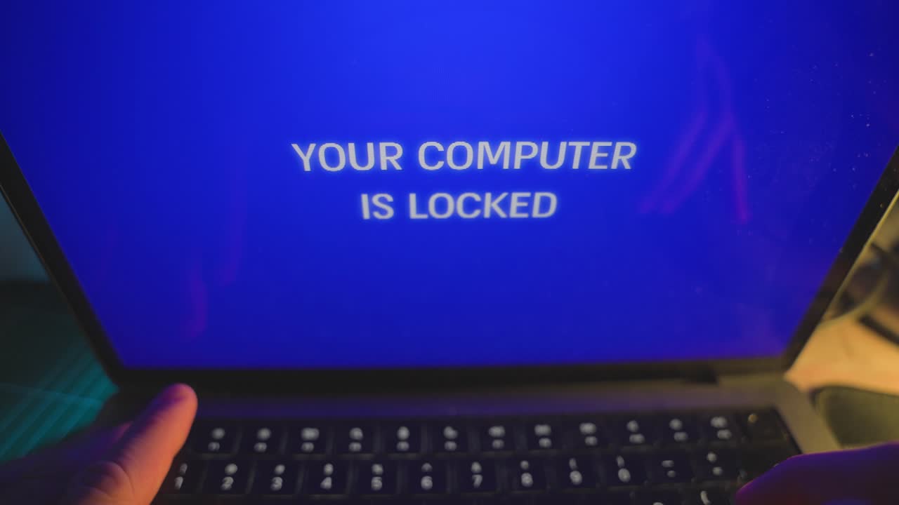 Person arbejder på bærbar computer, da en advarselsmeddelelse dukker op, og computeren låses og hackes af en hackergruppe eller spion. Fjernadgang til enheden af malware eller ransomware overtager pc'en. Advarselsmeddelelse i blåt.