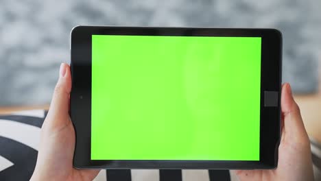 close up de mujer sosteniendo en las manos una tableta digital con pantalla verde para internet en línea, pantalla chromakey para publicidad.