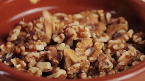 walnuts without shell falling down on red plate close-up . peeled nuts. healthy snacks. product rich in minerals and vitamins.