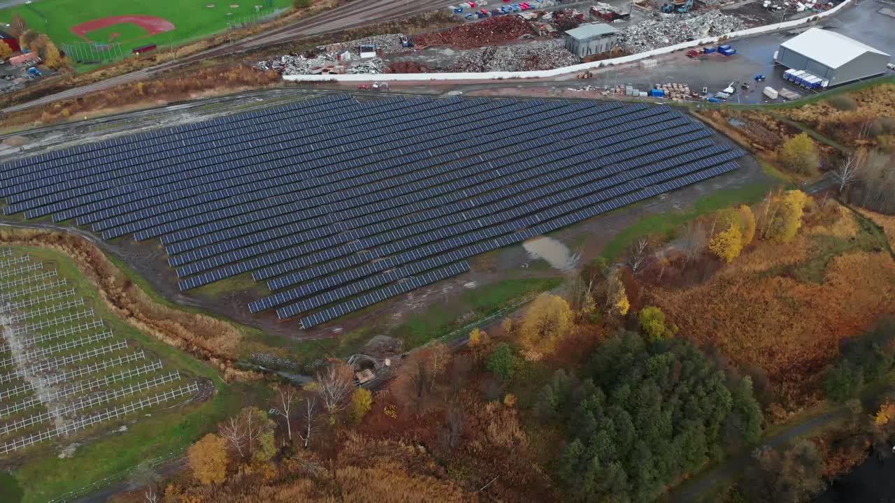 Aerial view of solar energy panels near a baseball field, pullback