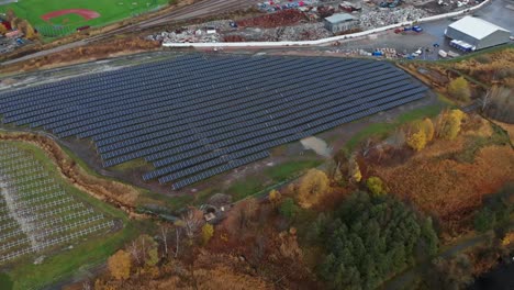 aerial view of solar energy panels near a baseball field, pullback