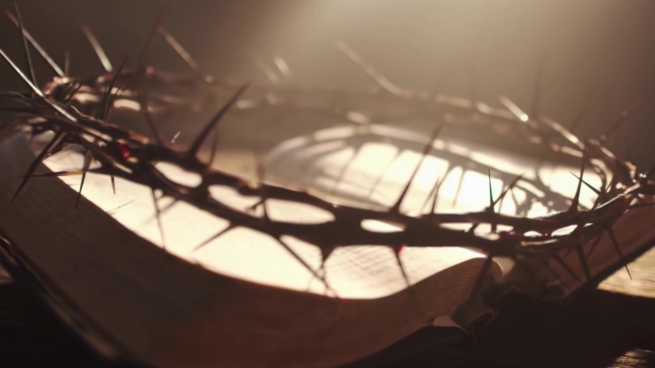 Crown of Thorns and Holy Bible with Blood Drops in Dramatic Light