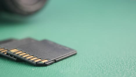 two sd cards on a green surface