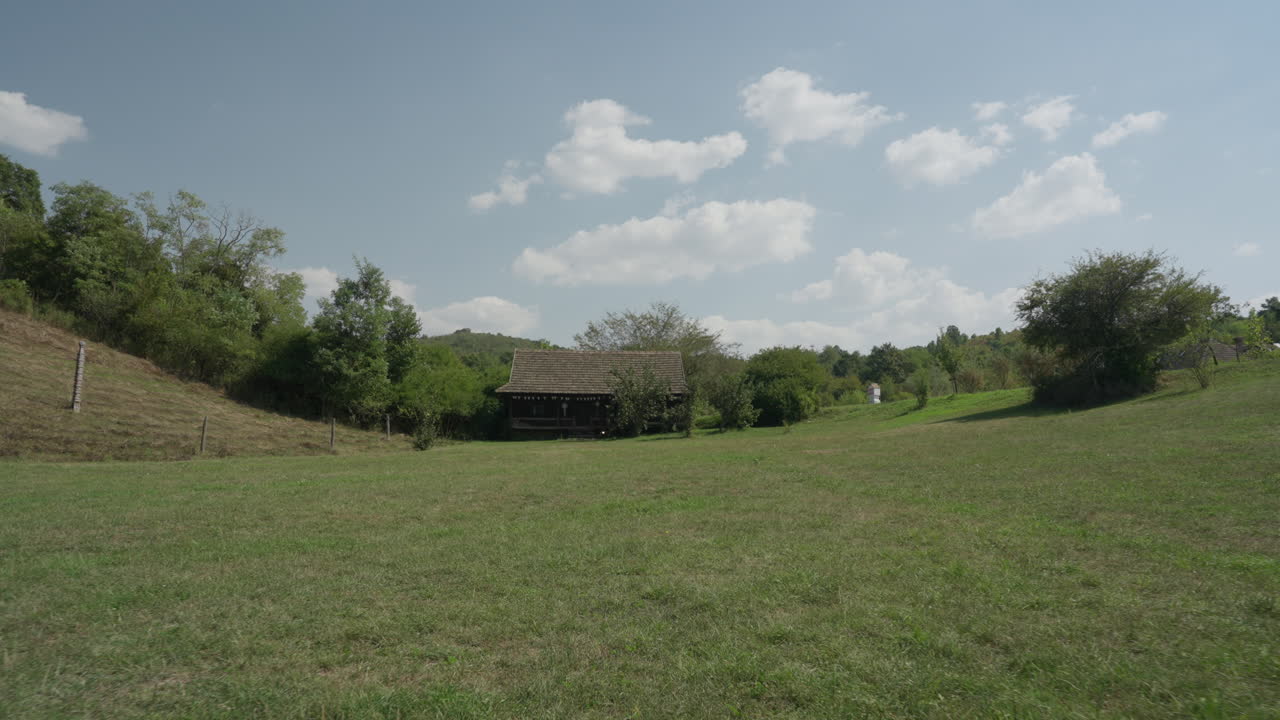 A charming wooden house nestled in nature during a bright summer day, offering a peaceful and serene atmosphere. Perfect for themes of nature, summer, and rustic living.