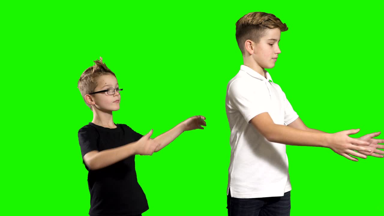 두 소년은 초록색 배경에서 서로 상자를 넘겨줍니다.