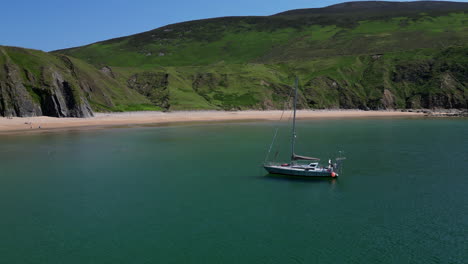 Boat-is-anchored-off-shore-from-a-beach-in-Donegal,-Ireland