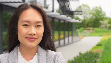 Portrait-Of-Serious-Businesswoman-Standing-Outside-Modern-Office-Building