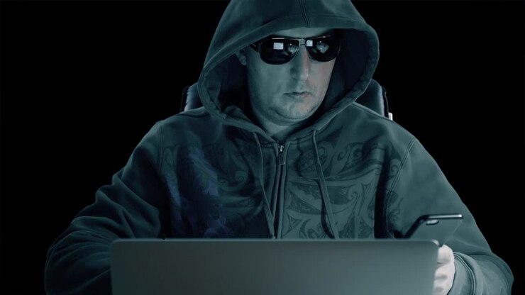 Hacker usa il telefono cellulare. Uomo adulto con cappuccio e occhiali siede al laptop di notte. L'uomo usa lo smartphone. Tecnologia moderna. Sfondo trasparente con canale alfa e chroma key.