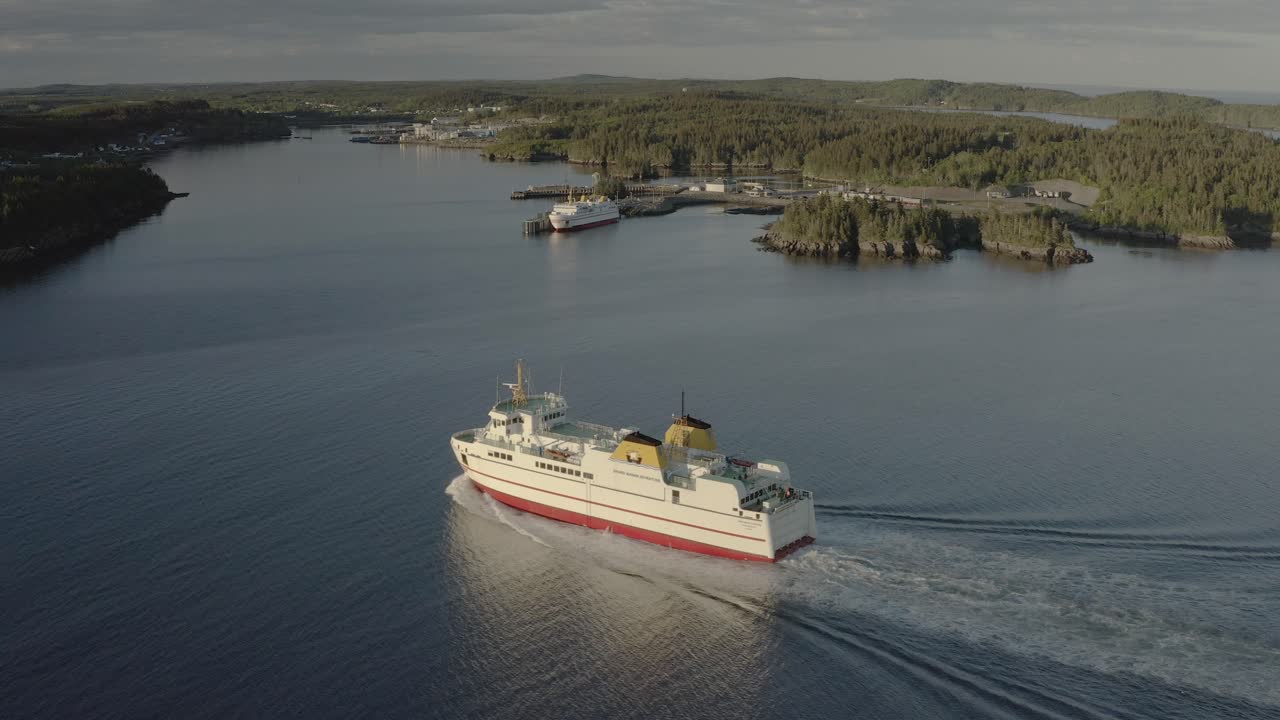 dolly toma izquierda del ferry que llega al muelle con la terminal en segundo plano.