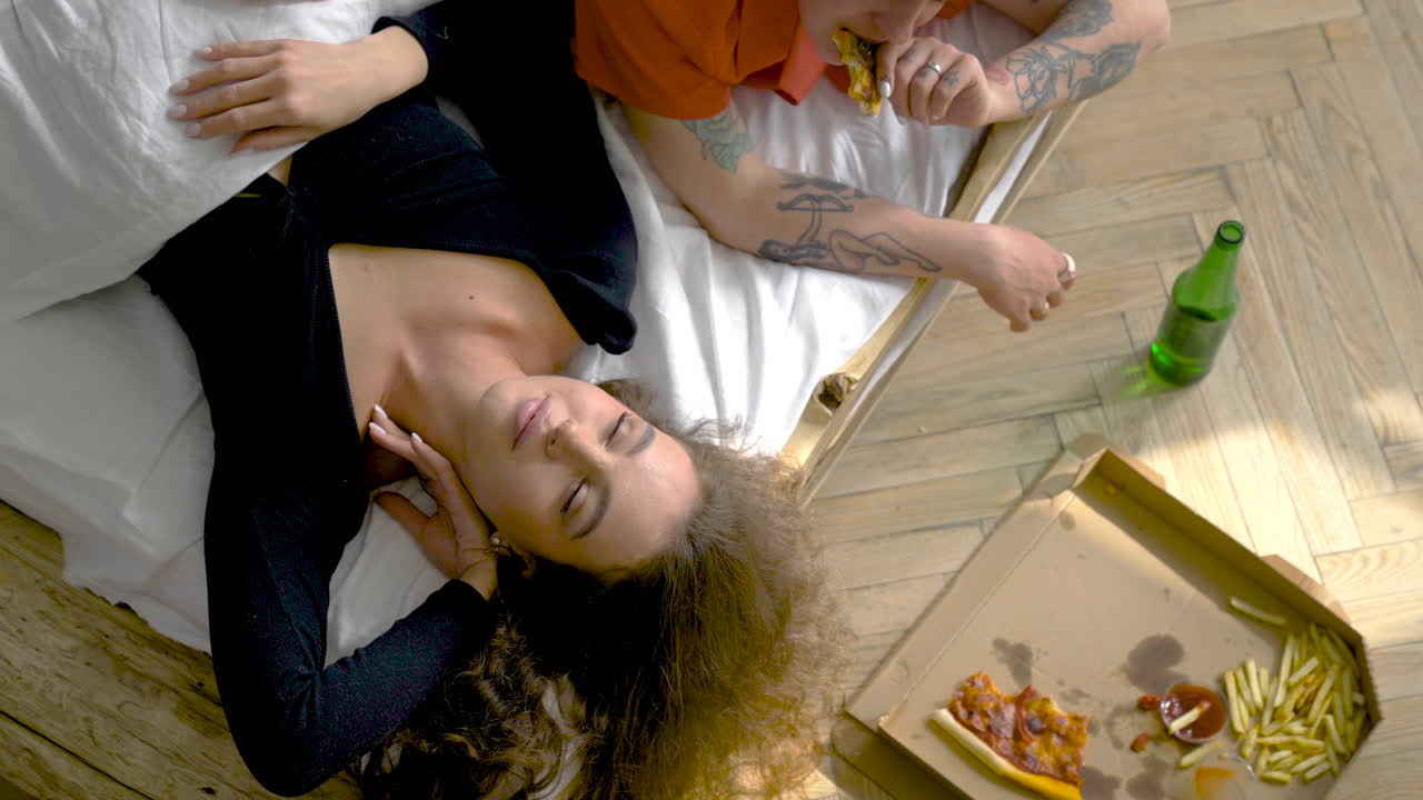 침대에서 편안한 네 여자의 상위 뷰