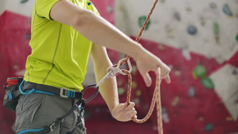 man belaying another climber with rope. top view of young athletic man belaying and watching another climber with rope. summer time. climbing equipment.