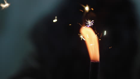 close up sparkler woman celebrating new years eve celebration holding festive fireworks at night