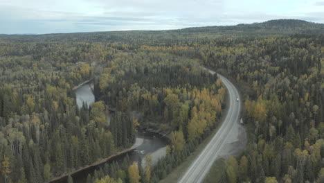 Aerial-flyover-of-cars-driving-remote-road-through-British-Columbia-in-autumn