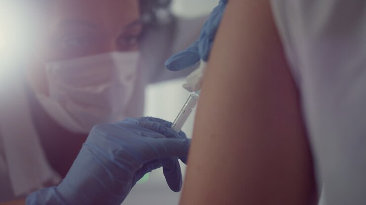 Face woman doctor making vaccine injection to patient visiting hospital close up
