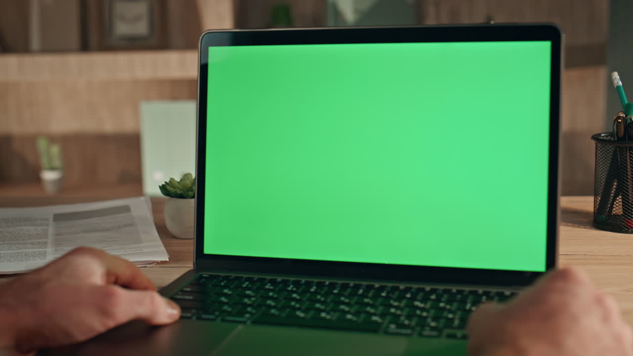 Online student watching mockup laptop at home close up. Man looking green screen