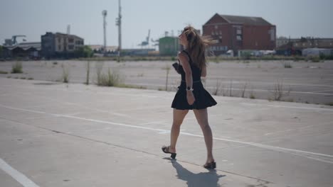young woman walking in urban parking lot