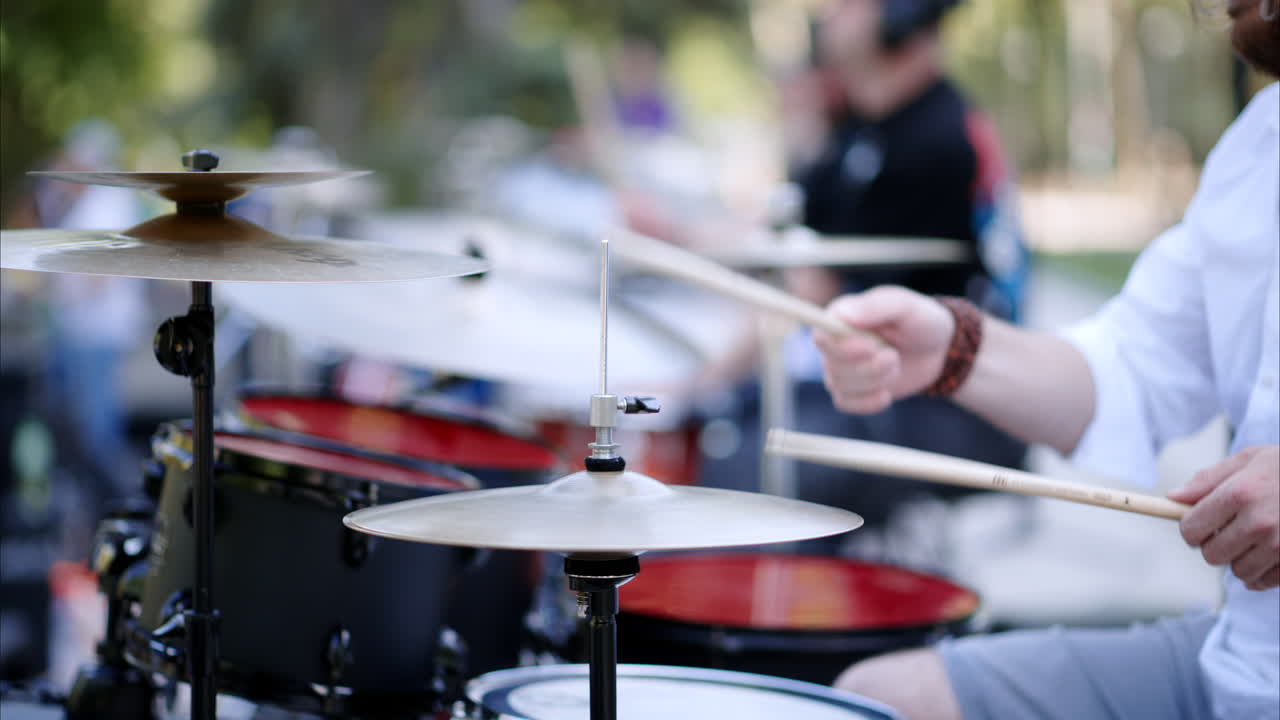 Close up of man playing red drums outside