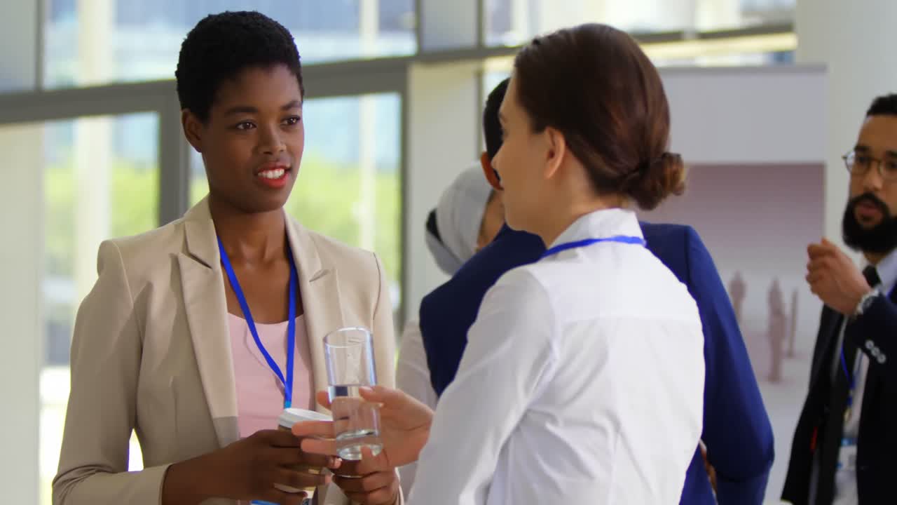 Multi ethnic business people interacting with each other at table during a seminar 4k