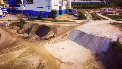 sitio industrial con camión de descarga y materiales