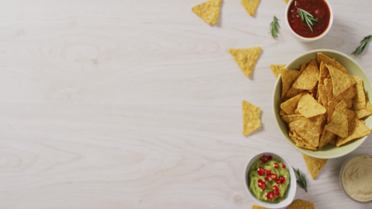 video de chips de tortilla, guacamole y salsa en una superficie de madera
