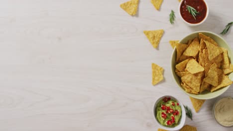 video of tortilla chips, guacamole and salsa dip on a wooden surface