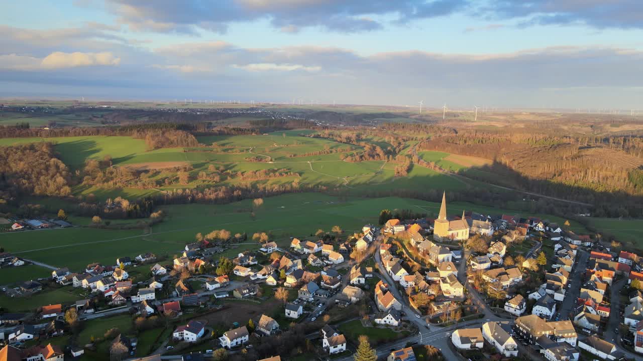 겨울 석양의 빛나는 빛 속의 칼렌하르트:독일 자우어란트 마을의 드론 샷