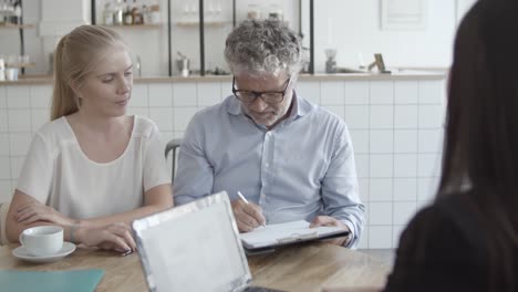 father and daughter signing health insurance agreement