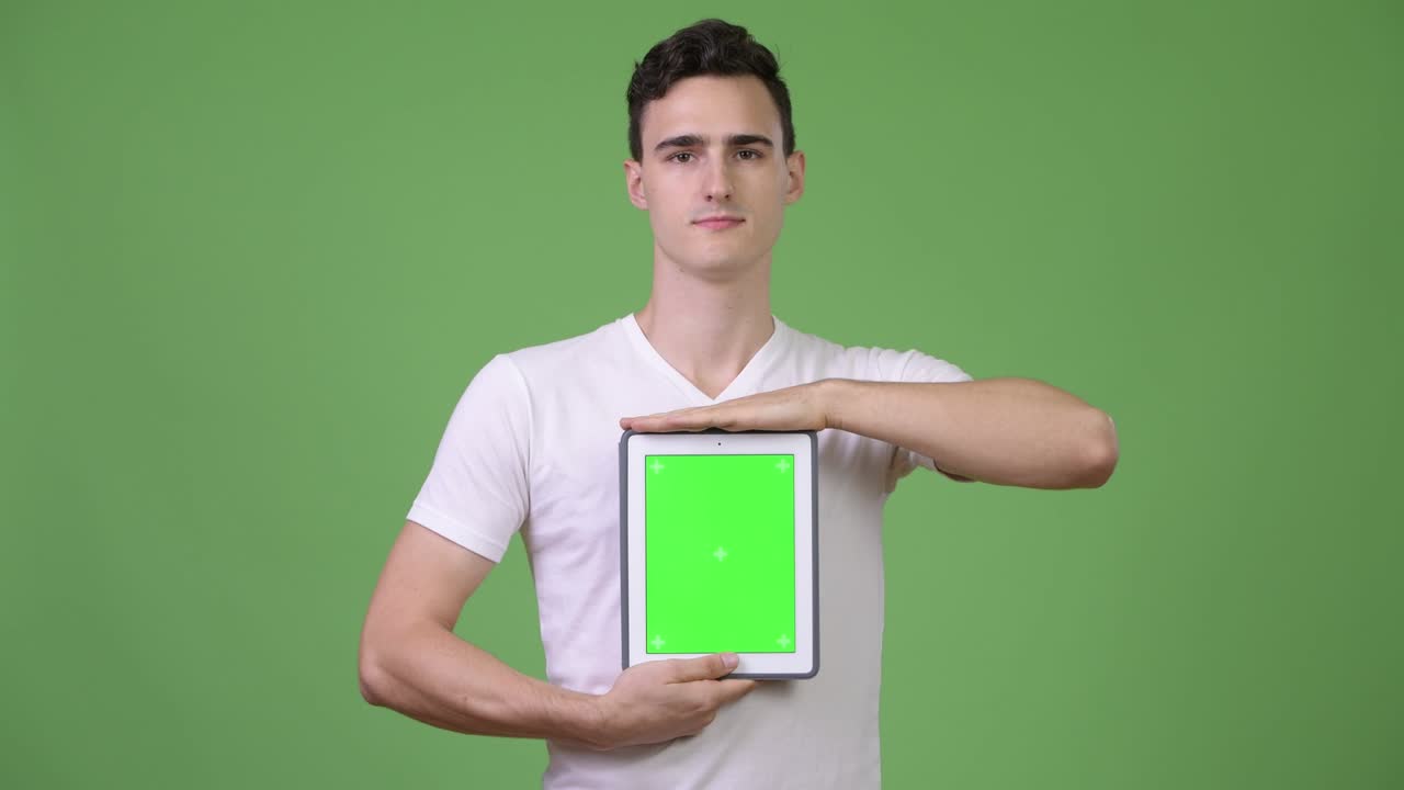 Young handsome man showing digital tablet