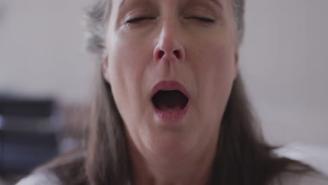 close up of sick woman with tissue coughing at home