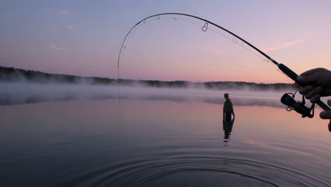 fishing at sunrise on a misty lake