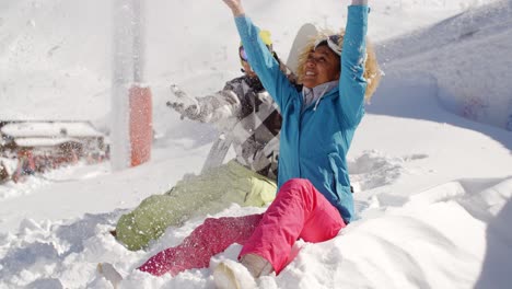 una pareja joven jugando en la nieve en una estación de esquí