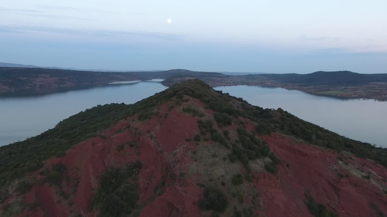 volando lejos de una montaña roja a lo largo del lago salagou en francia.