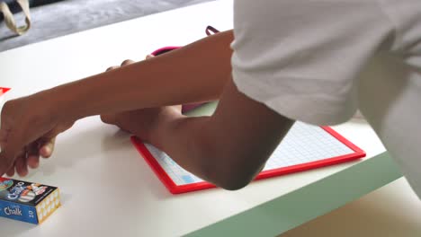 male student organizing his things on the table after class in the school