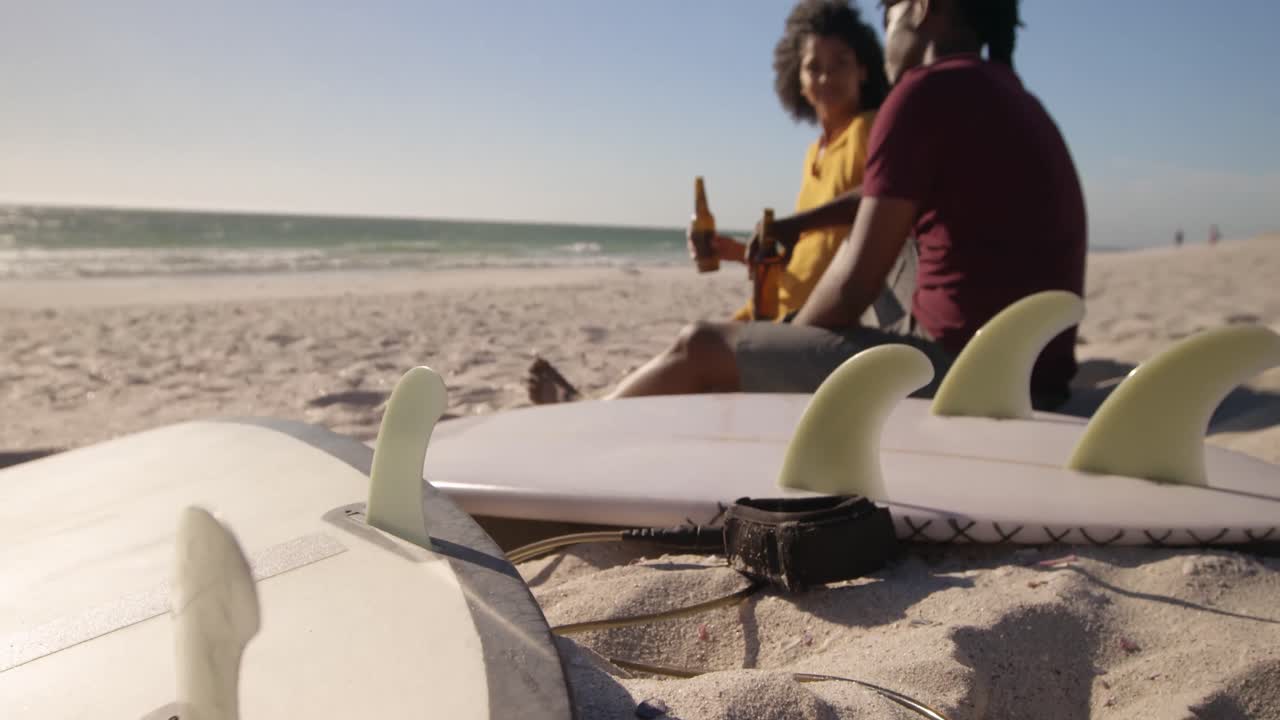 Couple toasting beer bottles on the beach 4k