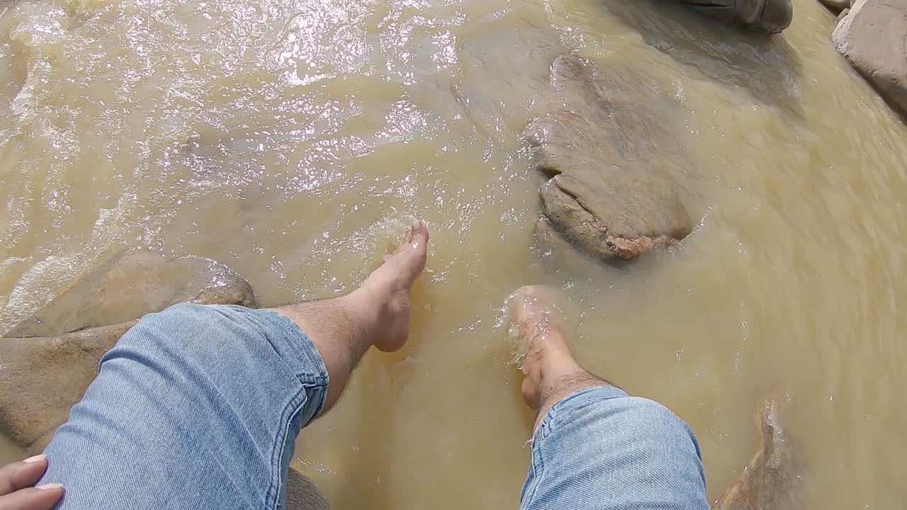 Person enjoying a refreshing dip in a fast-flowing river