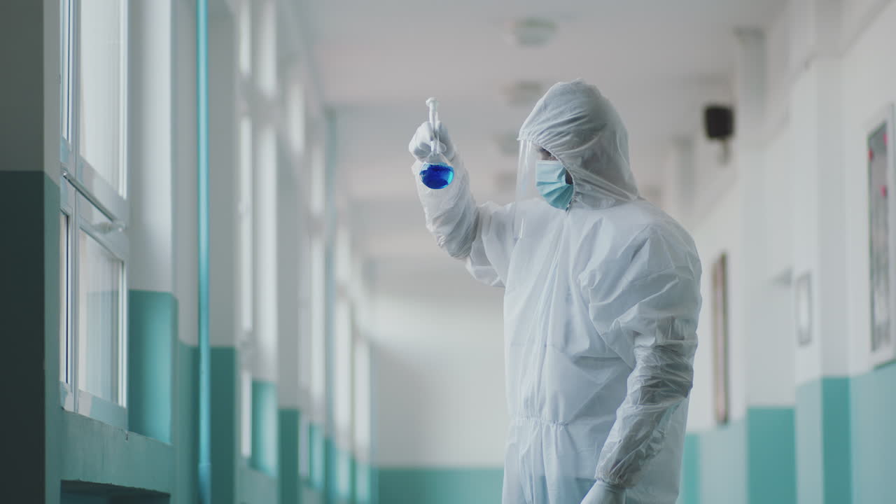 Scientist in Hazmat Suit Examining Flask